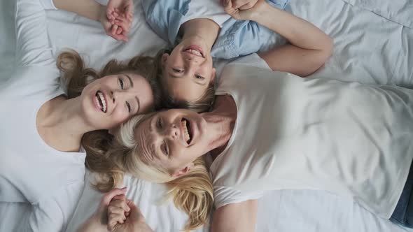 Three Generations Grandma Mom and Daughter  Happy and Smiling Lying Together