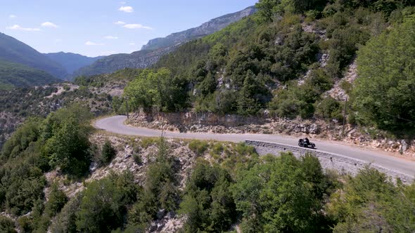 Aerial view of man driving motorcycle on mountain road