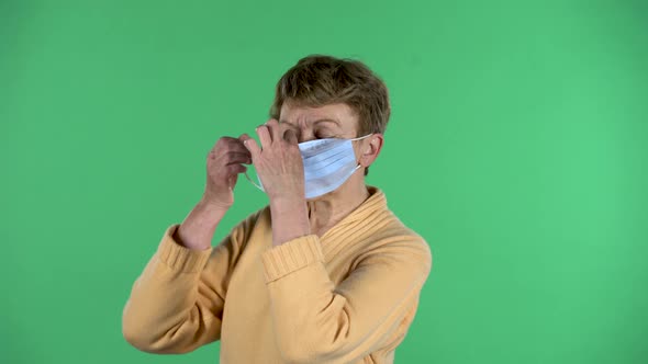Portrait of Elderly Woman Puts a Medical Mask on Her Face To Protecting Yourself From Coronavirus