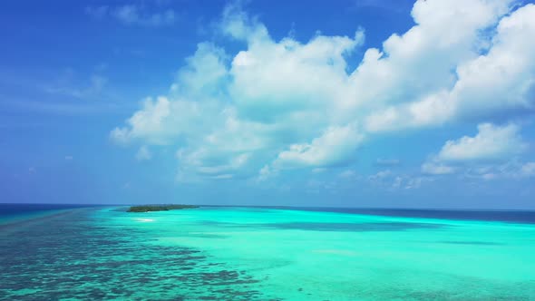 Daytime overhead travel shot of a paradise sunny white sand beach and aqua blue ocean background 