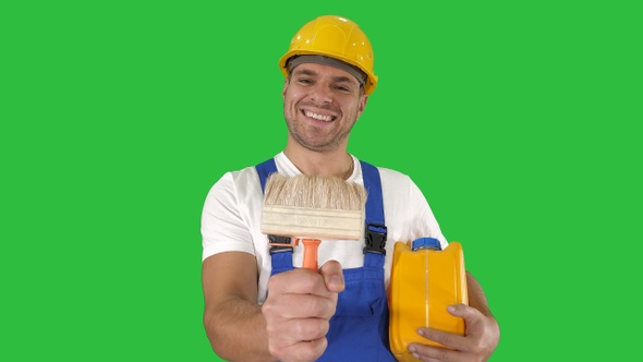 Construction worker painter showing paint brush to camera