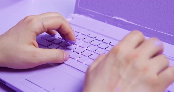 Freelancer Types Text on Laptop Painted in Purple Color