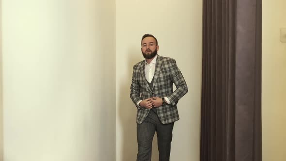 Stylish Young Man In Fitting Room Trying On New Suit.