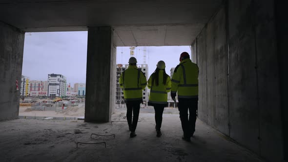 Civil Engineers are Walking in Building Under Construction Rear View of Female and Male Professional alt