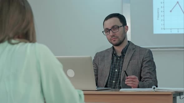 Male Teacher Listening To Students at Adult Education Class