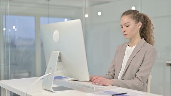 Young Businesswoman Thinking and Working on Desk Top in Office