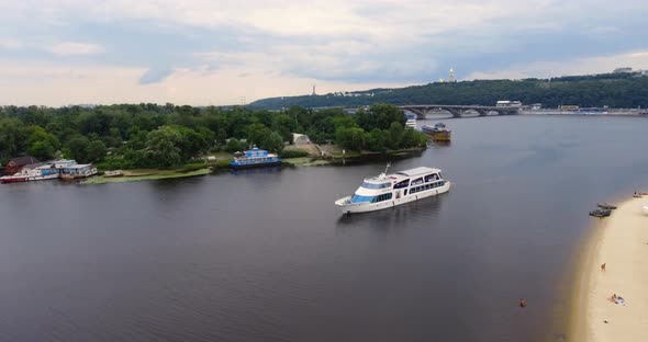 Passenger Ship Sails along City River Side View