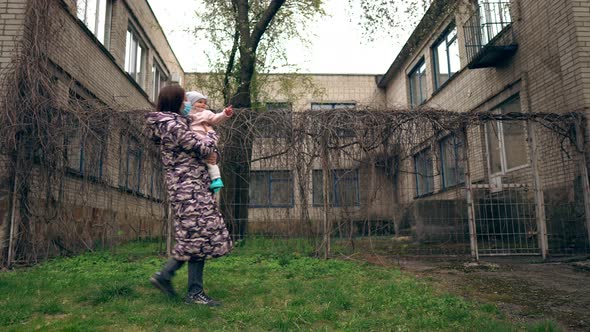 Nanny with a Baby Outside During the Pandemic. Health Care and Medical Concept. Lockdown Lifestyle.