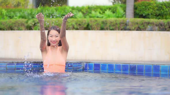 Young asian woman enjoy around outdoor swimming pool for leisure