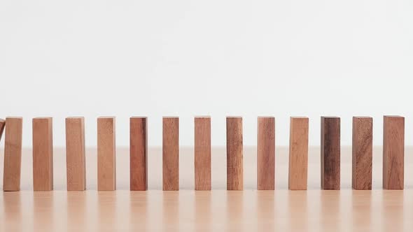 Slow motion, Domino effect made up from wooden blocks shape toy on wooden desk