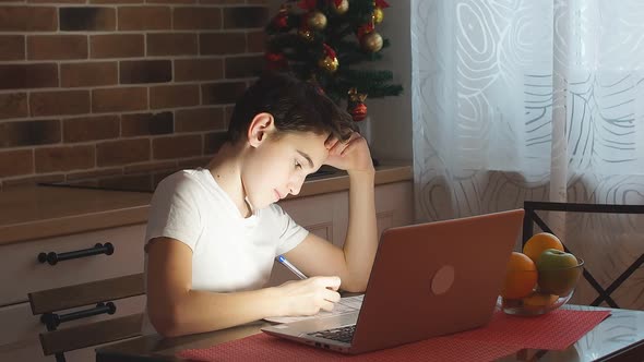 Little Boy Doing Homework at Home Using Laptop