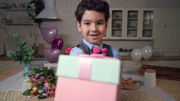 Portrait of Little Boy Offering Gift Box on Camera