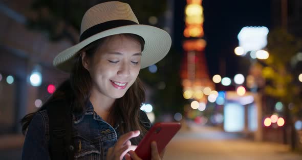 Woman use of mobile phone in Tokyo city at night 