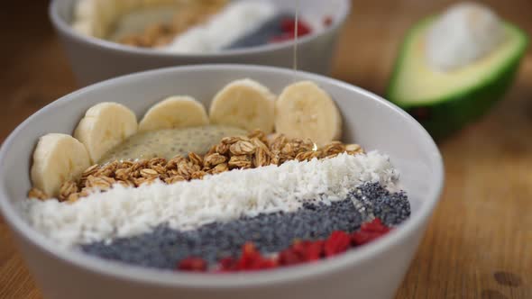 Pouring Syrup on a Healthy Organic Vegan Smoothie Bowl