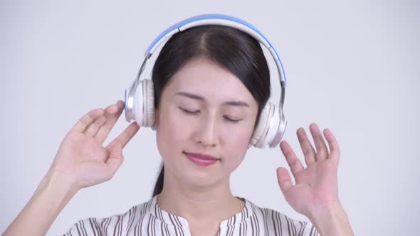 Face of Happy Beautiful Asian Businesswoman Listening To Music with Eyes Closed