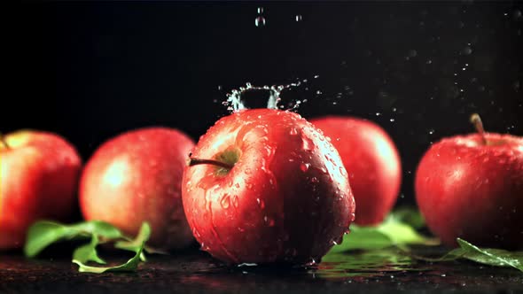 Water with Splashes Falls on the Red Apple