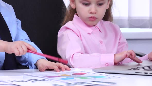 Children Businessmen Looking at the Charts and Diagravy While Discussing Important Issues