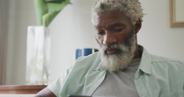 Video of sad african american senior man sitting alone