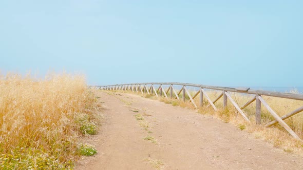 Dirt Road with Wooden Fence to the Sea