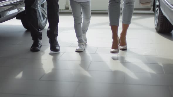 Legs of Family Walking in Car Showroom