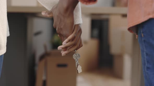 Close Up of African American Couple Holding Hands and Keys to New Apartment Over Background with