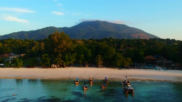 A shot of a waterfront with white sandy beach and boat.