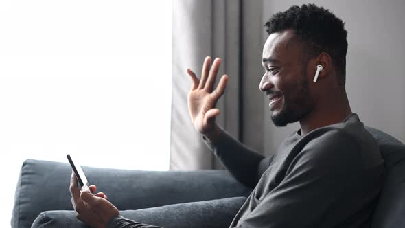 An AfricanAmerican Guy with a Smartphone at Home