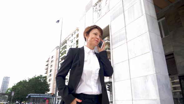 Slow motion shot of businesswoman using smartphone in city