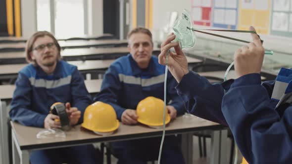 Woman Showing How To Use Oxygen Mask At Factory