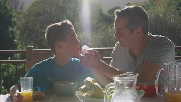 Family eating breakfast together outdoors