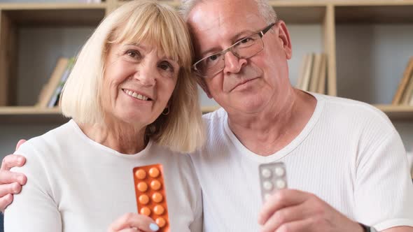 Portrait of Smiling Senior Couple in Love Holding Pills