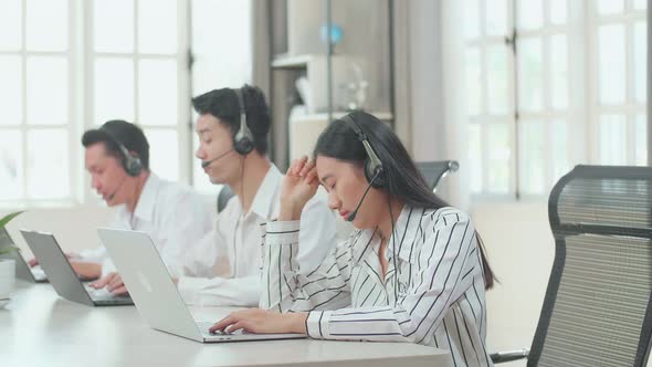 A Woman Of Three Asian Call Centre Agents Tired Due To Working At The Office