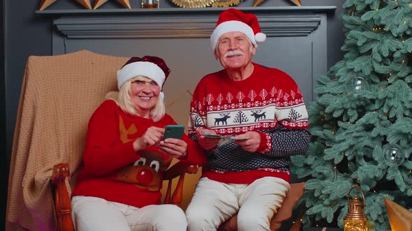 Senior Family Couple Searching Purchase Online Christmas Gifts in Mobile Phone Application at Home