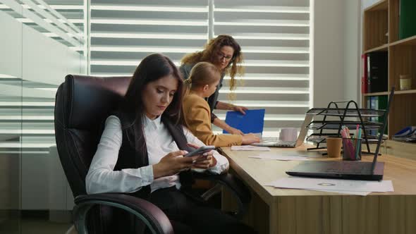 Female nervous chatting on the phone being in the office with two coworkers