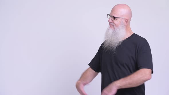 Happy Mature Bald Bearded Man Smiling While Showing Something