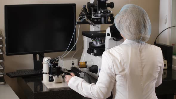 Microbiologist Working on Microscope in Laboratory