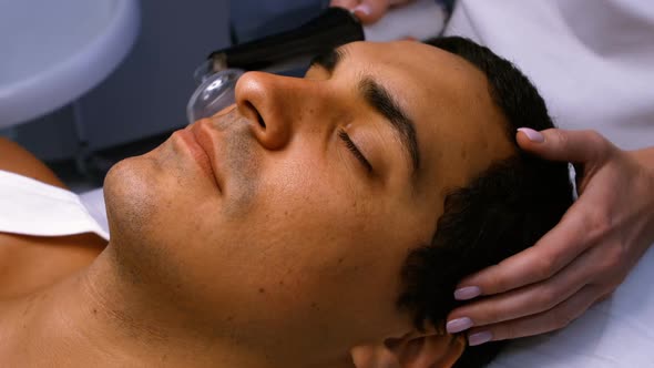 Doctor performing laser hair removal on patient face