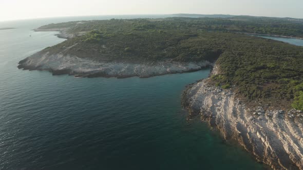 Aerial shot of a small lagoon at Cape Kamenjak, Drone dollies in to reveal more details. Backlight f