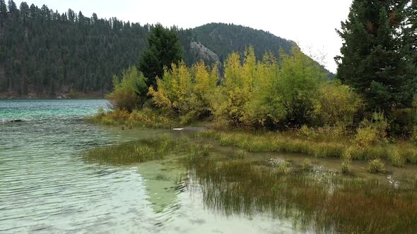 Rotating over Cliff Lake revealing camper on shoreline at campsite