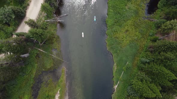 Overhead drone shot following paddleboarders and kayakers on the Payette River in the Idaho wilderne