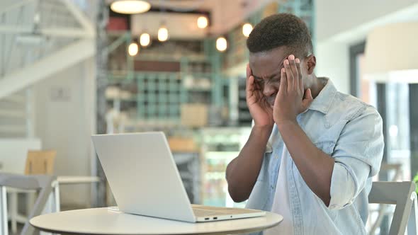 African Man with Laptop having Headache