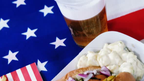 Hot dog, french fries and glass of beer served on American flag