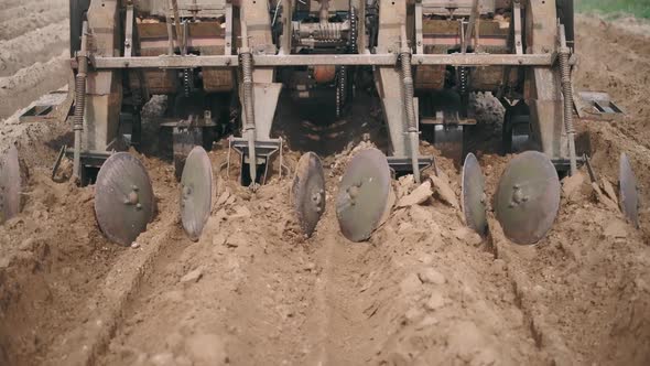 Close-up of a Plow That Plows the Land in a Field and in the Ground Cuts a Ditch for planting