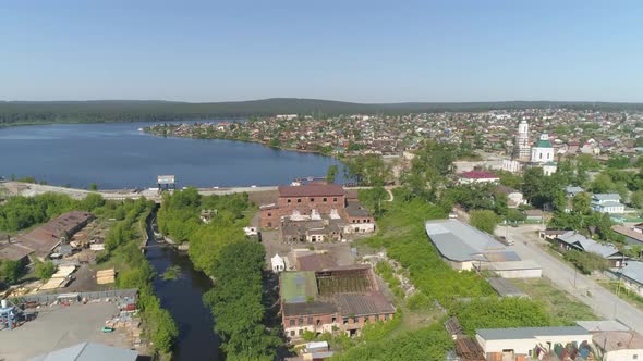 Aerial view of old red brick factory next to the river, pond and church 15