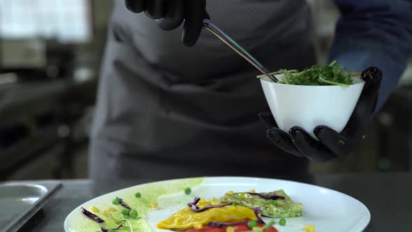 Chef in Black Gloves Puts Greens on Pancakes with Tongs