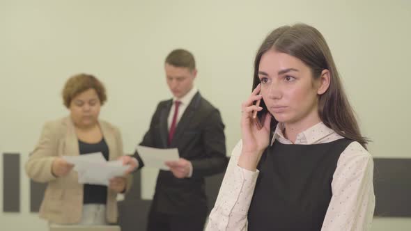 Portrait of Adorable Attractive Young Woman in Formal Wear Talking By Cellphone in the Foreground