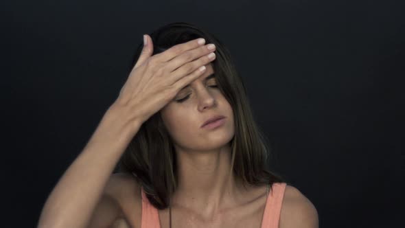 Woman with a headache, holding hand against forehead