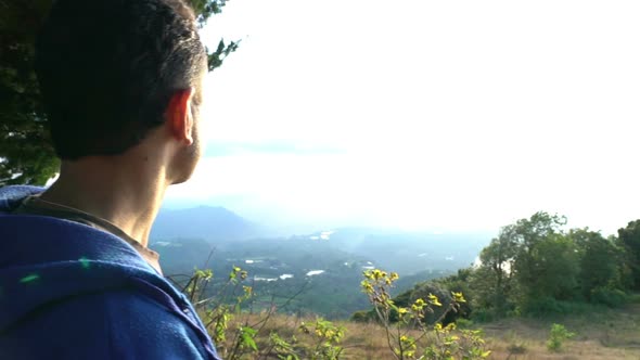 Man Standing on the Edge of Mountains and Enjoy the Beautiful View