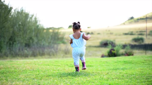 Two year old South African girl running away from camera