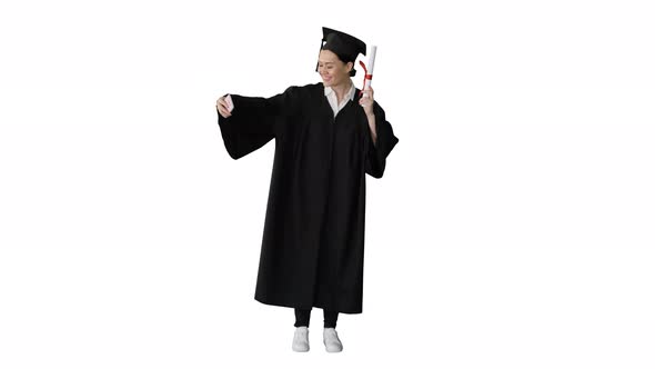 Happy Female Graduate Holding Diploma and Making Selfie on Her Phone on White Background.